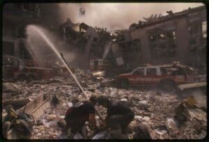 Two rescue workers direct a firehose at the ruins of the World Trade Center following the 9/11 terrorist attacks